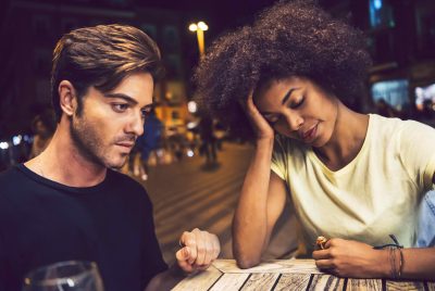 Casual interracial couple having an argument in a terrace